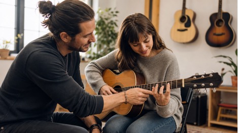 teacher helping guitar student
